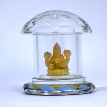 Gold figurine inside a clear glass dome on a white background